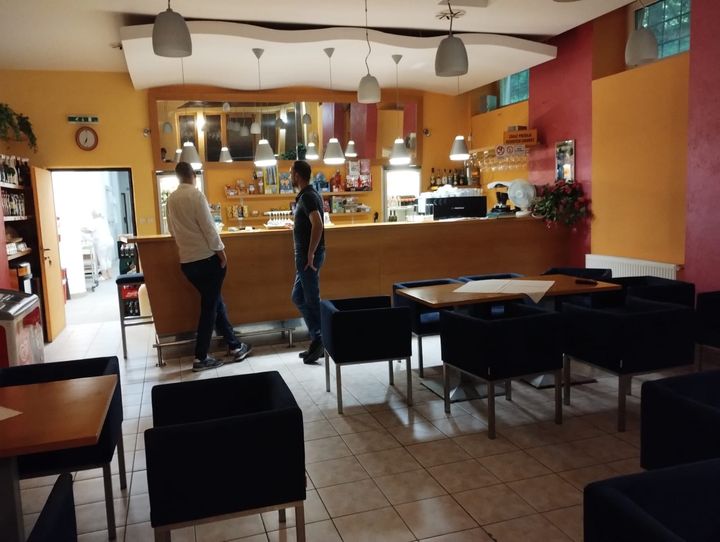 Denný bar so sedením a dvomi zákazníkmi pri pulte