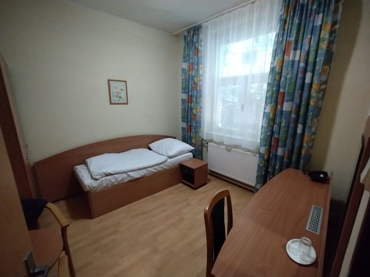 Hotelová izba s jednou posteľou a stolíkom so stoličkou