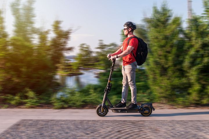 Muž na elektrickej kolobežke v pohybe prírodou