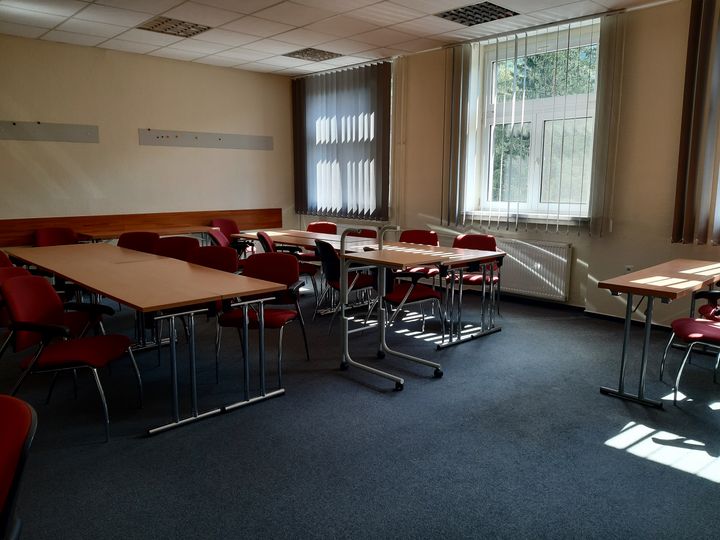 Učebňa s konferenčnými stolmi a stoličkami